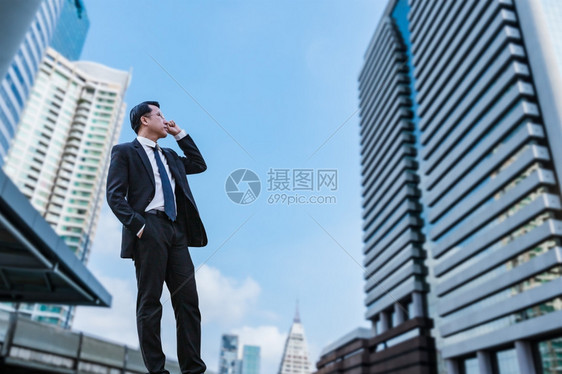 充满自信的商人站立一看城市的愿景概念图片