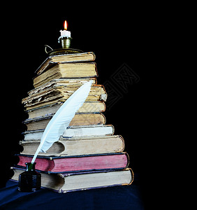 高堆旧书蜡烛在台燃烧白色羽毛在墨水井图片