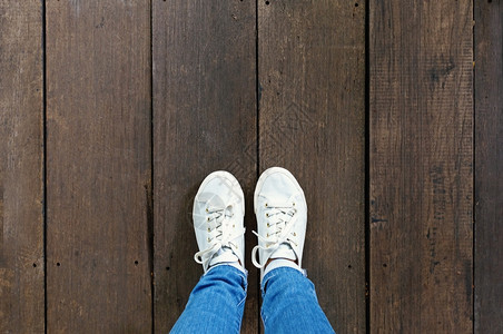 木地板背景的时装运动鞋上脚的自足运动鞋带有复制空间的顶视图图片