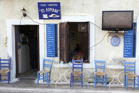 在Mesnia的贝罗蓬内斯渔民村的贝罗蓬内斯尼科洛奥村铺路面的希腊咖啡厅蓝椅子图片