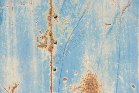 粗底料含蓝色涂粉片和破碎纹理的生锈金属表面有接缝和图片