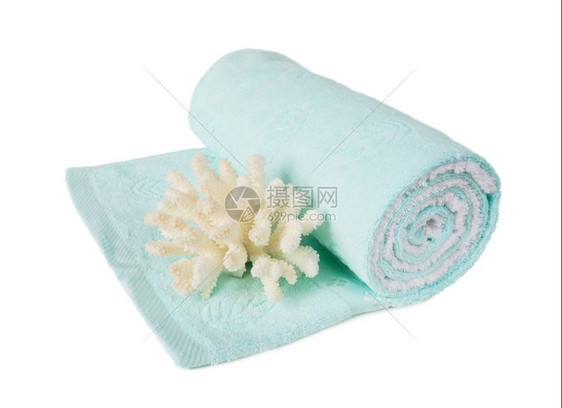 蓝色毛巾布卷成一卷白色背景上有一个美丽的大白珊瑚图片