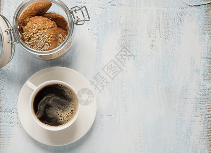 黑咖啡红白瓷杯和燕麦饼干玻璃罐子浅木背景有文字空间顶视图图片
