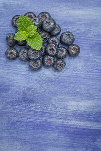 具有复制空间的生锈纹质背景上新鲜蓝莓和薄叶图片