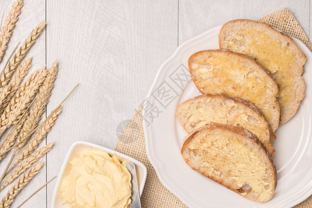 新鲜面包小麦加和木本底的自制黄油带有复制空间的顶端视图图片