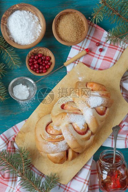 甜的圣诞糕点上面有个牛莓果酱环绕着圆形树枝的旧切割板顶层风景图片