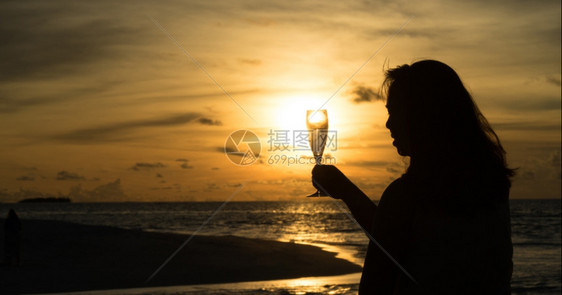 美丽日落时以酒配着女休月图片