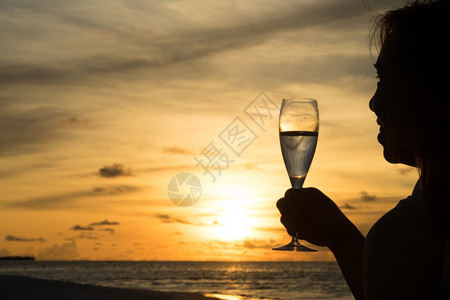 美丽日落时以酒配着女休月图片