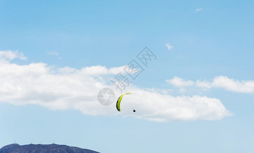 在山地和蓝天背景下云层运动员正在规划滑翔伞图片