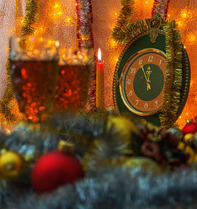 前景是m2杯圣诞玩具前景脱离焦点在背景蜡烛和时钟中间是5到12无焦点的亮和时间是分钟到背景照亮了garlnd图片