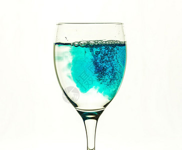 蓝色液体用透明水填满玻璃杯图片