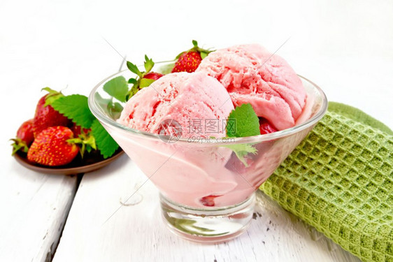 杯子里有浆果和薄荷的冰淇淋草莓木板底的餐巾纸图片