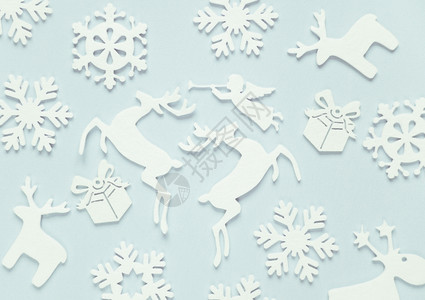 由白月装饰组成的圣诞节背景雪花鹿飞行天使和蓝色背景的礼品盒圣诞墙纸网站社交媒体企业主杂志博客艺术家等的平面布局图片