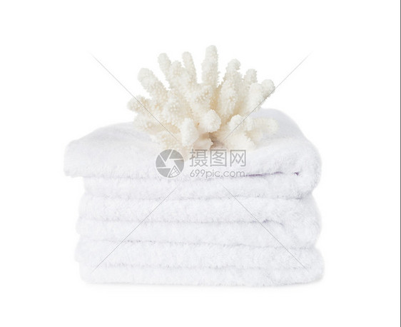 美丽的大白珊瑚上的白色毛绒毛巾堆隔离在一个白色的背景白毛巾上的白珊瑚图片