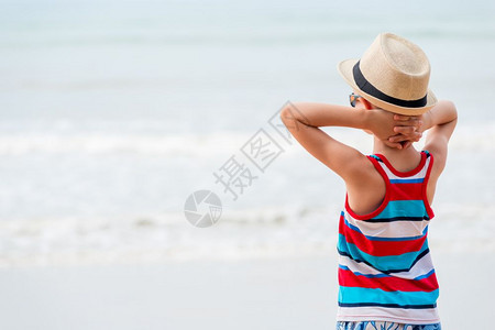男孩在帽子和太阳眼镜仰慕大海图片