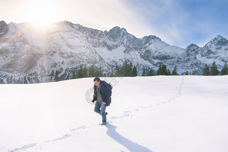 代表冬季的景象有雪山峰森林和一个人游荡在厚的雪层上在奥斯特里亚的厄尔瓦德图片