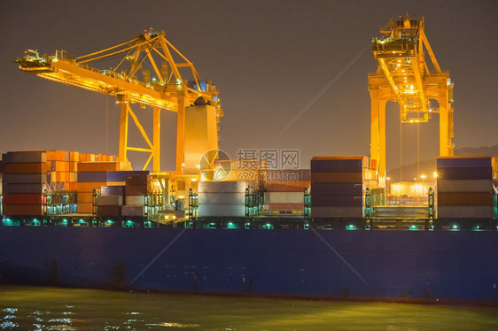 夜间商业港口的起重机船舶和集装箱图片