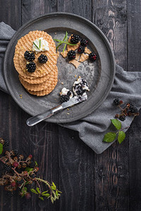 美味的早餐贝吉亚华夫饼和新鲜的野生黑莓和底的奶油酪图片