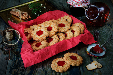 甜的圣诞饼干在旧木制桌子上加果酱和树枝图片