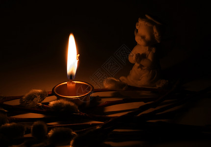 天使燃烧的蜡烛和柳树枝图片