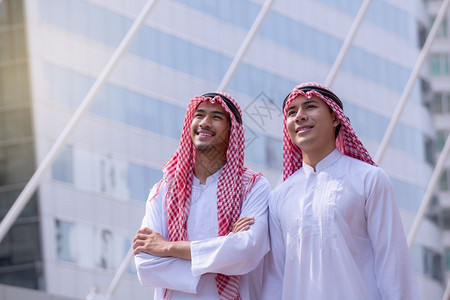 有自信的阿拉伯商人站立一看城市背景展望概念图片