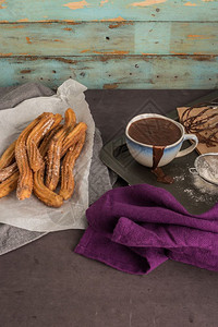 传统的西班牙和墨哥甜圈黑石背景上加热巧克力酱图片