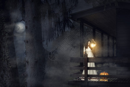 女孩拿着灯笼在木屋阳台上图片
