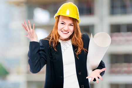建筑工地在黄色头盔上画图的女首席建筑师图片