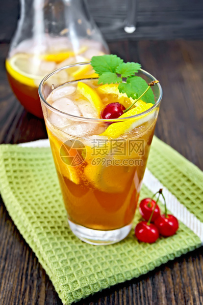柠檬汁在玻璃杯和罐子中樱桃柠檬橙子和薄荷放在木板底的绿毛巾上图片