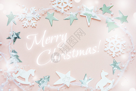 圣诞节贺卡由白圣诞节装饰品组成雪花星圣诞树和玩具粉红色背景的摇摆马刻有欢乐圣诞节的字样贺卡网站社交媒体杂志博客艺术家等的平板布局图片