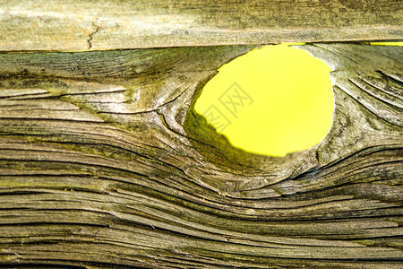 带有洞和视图为黄色背景的旧木板图片