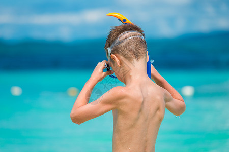 孩子们在热带海岸的上戴着下潜面罩图片