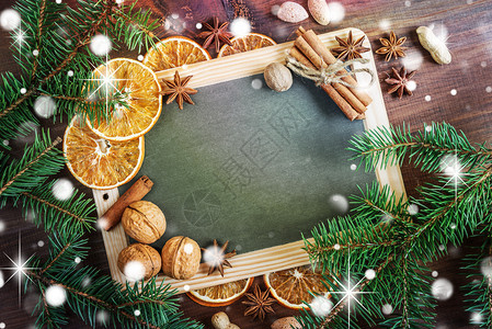 圣诞节贺卡空黑板周围环绕绿色圆形枝坚果橙子和香料有文字空间图片