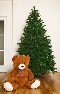 赤裸的人工圣诞树与泰迪熊的房子图片