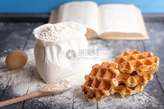 以一副美味的比利时华夫饼鸡蛋一袋面粉和本公开的烹饪书图片