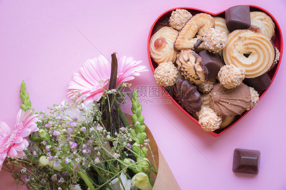 红心盒装满美味甜食粉红背景花束贺卡想法图片