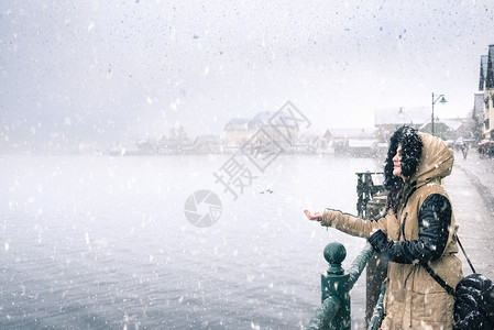 站在岸边感受下雪的年轻女子图片