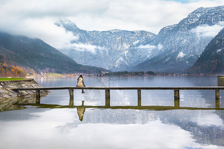 女人坐在湖的木桥上图片