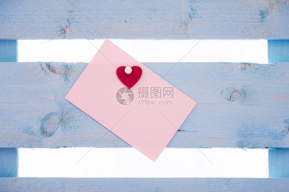 白粉红色纸条的心粘在一起被钉在蓝色的木栅栏上图片