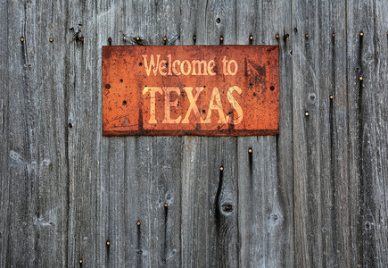 木制墙上有生锈的金属标志上面写着欢迎来到德克萨斯图片