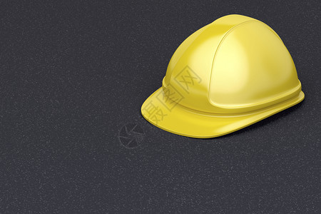 沥青上的黄色安全头盔图片