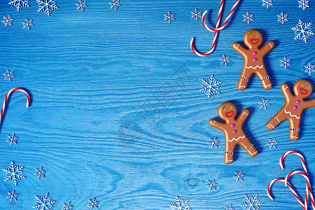 圣诞背景姜饼人圣诞糖果甘蔗和蓝木本底雪花并有文本复制空间图片