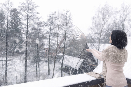站在阳台上看雪的女人图片