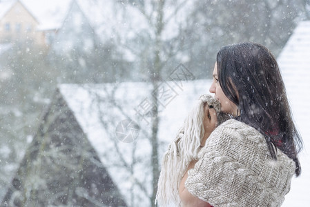 美丽的黑发女抓住她的披肩围绕身体和面孔享受童话般的雪崩图片