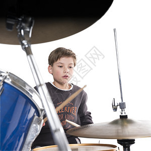白色背景在工作室的鼓包里金发小男孩图片