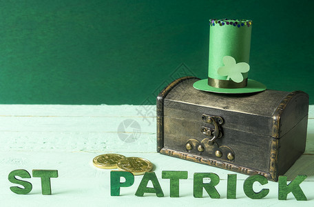 圣徒patrick写成绿色木字高的帽子具体用于圣徒patrick节日在一个旧的宝藏库顶上旁边有金币图片