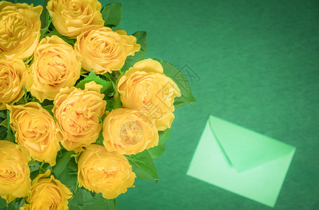 美丽的黄玫瑰花束和绿木背景的封闭信贺卡想法或国际妇女节框架背景图片