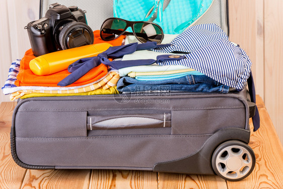 一个装满东西的行李手提箱用于海上度假图片