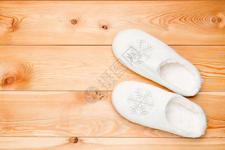 二对白色温暖的拖鞋上面木制地板有雪花从面看图片