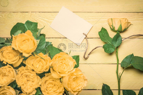 带玫瑰花束和一朵的贺卡插件上面有一张空白的贺卡上面有一张单线条挂在黄色木制桌子上图片
